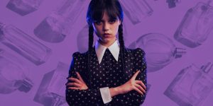 Personagem Wandinha; ao fundo, uma montagem de cor roxa com vários frascos de perfume