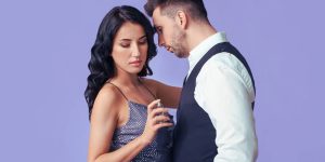 Casal abraçado, com o homem cheirando o pescoço da mulher